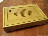 Closed bamboo storage box showing the decorative slatted pattern on the lid with circular opening for lifting.