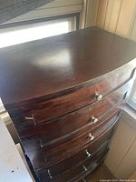 Front angled view showing curved front and metal drawer pulls.