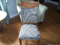 Front view of the wooden French Provincial style chair showing paisley patterned upholstered seat and backrest.