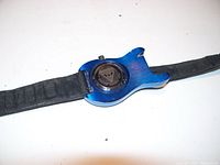 Back view of blue guitar-shaped watch case showing battery cover and black leather strap.