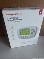 Front view of the Honeywell Home RTH6580WF Smart Thermostat box showing the thermostat image and key features.