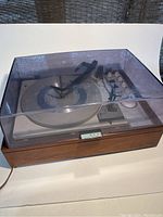 Photo showing vintage KLH Model Twenty turntable with clear plastic dust cover and wooden frame.