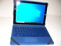 Microsoft Surface tablet open with blue detachable keyboard and Windows 10 desktop visible on screen