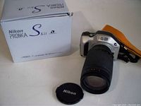 Photo showing Nikon Pronea S camera, Nikon lens cap, and original box labeled Nikon Pronea S Kit.