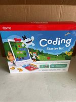 Front of Osmo Coding Starter Kit box showing colorful artwork and branding with tablet illustration