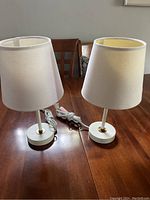 Pair of small table lamps side by side on wood table, showing overall size and style