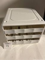 Front view of the white plastic spice rack with three drawers designed for organizing spices.