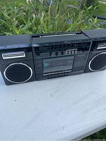 Front view of Toshiba RT-7177 vintage stereo cassette radio showing left speaker and controls with cassette player.