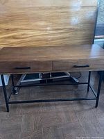 Full view of the wooden wall table desk with two drawers on a metal frame.