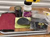 Gardening items including metal frame seat, spool of wire cord, spray bottle, solar garden lights, red gardening glove.