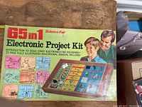 Photo of the 65 in 1 Electronic Project Kit box showing the full front with colorful illustrations and title.