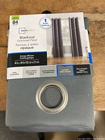 Front view of the curtain box showing brand Mainstays, panel size 40 in. x 84 in., and features like energy efficiency, blackout opaque, and 100% blackout.