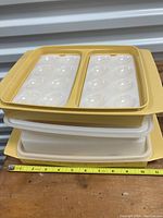 Stack of two Tupperware deviled egg trays with lids showing measurements of approximately 12 inches width.
