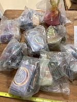 Photo of all 9 Lord of the Rings Burger King collectible figurines in their original sealed plastic packaging on a wooden table.