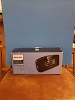 Box front showing Philips Clock Radio, large yellow LED display displaying time 12:38.