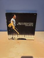 Front cover of Bruce Springsteen & The E Street Band Live 1975-85 vinyl box set showing Bruce on stage with guitar.
