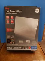 Front of the box showing product name GE Pro Flat Panel HD 50 Amplified Antenna with features and supported types like Full HD and 4K. Shows PureUp technology and mounting options.