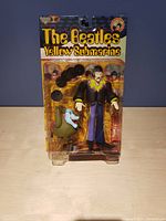 Front view of boxed John Lennon and Jeremy Yellow Submarine figures showing packaging and figures inside.