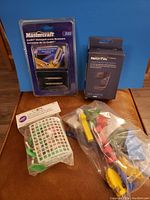 Photo showing all included items: Mastercraft screw removers, MicroTek webcam box, Wilton cookie cutter, bag of rubber toys