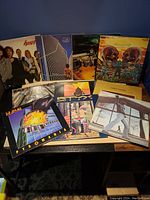 Photo showing multiple rock vinyl albums arranged on a table, including Heart, Yes, Thin Lizzy, Journey, Def Leppard, Mountain, and others