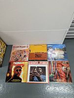 Front view of six vinyl LP record covers arranged on the floor in two rows of three.