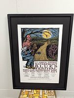 Full view of the framed festival poster showing artwork and text including dates and location