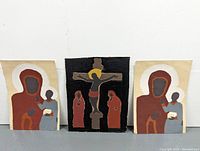 Frontal view of three paintings on recycled cardboard