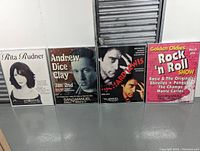 Four framed San Manuel promotional posters displayed upright on floor showing Rita Rudner, Andrew Dice Clay, Richard Lewis, and a Rock n Roll show