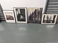 Four framed modern prints displayed against a wall, showing variety in style and size.