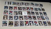 Photo showing a large spread of 2020 Bowman rookie baseball cards laid out on a surface, displaying the front images and player details.