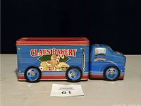Side view of blue Claus Bakery delivery truck tin with bakery themed graphics including gingerbread and candy canes on side panel.