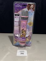 Front view of the Disney Princess karaoke microphone in its blister packaging showing microphone details and graphics.