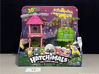 Front view of Hatchimals Colleggtibles Tropical Party Playset in original packaging showing colorful tropical themed playset, figures, and egg with branding and product information.