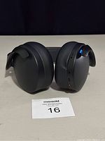 Front view of the black wireless over-ear gaming headset with visible controls and LED light on the right ear cup.