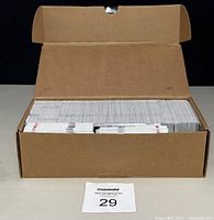 Front view of a plain brown cardboard box filled with a large number of hockey cards packed upright.