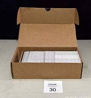 Cardboard box filled with hockey cards displayed on a white surface.