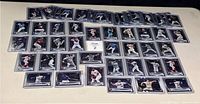 Topps Chrome 2022 baseball rookie cards laid out on flat surface, showing two rows of 28 cards and one row of a single card, all sleeved.