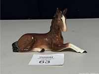 Photo of vintage Sylvac brown foal horse lying down, front and side view