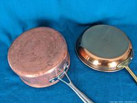 Bottom view showing copper exteriors and handles attached by rivets