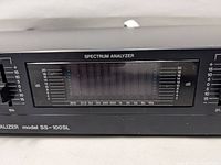 Front close-up of the central spectrum analyzer with frequency range and dB levels visible.