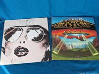 Boston and Prism vinyl record covers side by side on blue background