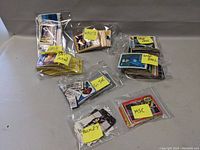 Multiple stacks of collectible cards grouped and marked with sticky notes labeled Baseball, Hockey, GI Joe, Batman, and Misc.