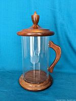 Full view of Cuban style humidor, showing clear glass cylinder with wooden base, handle and lid with finial