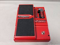 Top view of red Digitech Whammy pedal showing black treadle and rotary knob with effect labels.