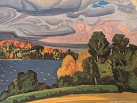 Close-up of fall lake landscape showing colorful trees, water, and swirling sky.