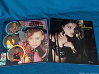 Two vinyl records shown together on blue fabric background, Culture Club's 'Colour By Numbers' and Madonna's 'Borderline' single