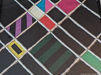 Close-up showing metallic silver intersecting lines and colorful geometric blocks