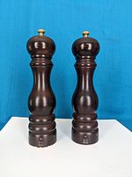 Front view of the pair of wooden Peugeot grinders showing classic design and wood finish.