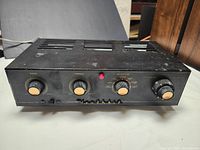 Front view of black metal chassis with four control knobs labeled Bass, Treble, Selector, Volume, red power indicator and Heathkit logo.