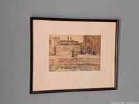 Framed watercolour painting hung on wall showing full artwork with mat and dark frame